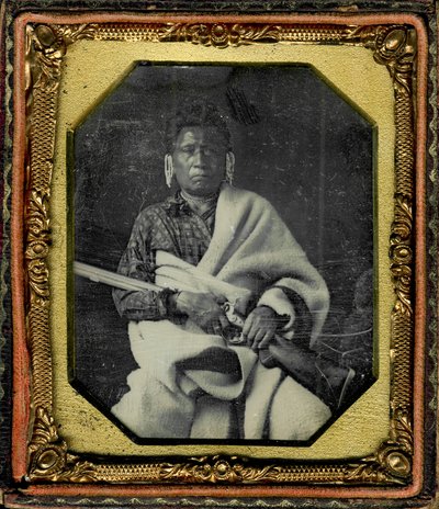 Portrait of Nacheninga [No Heart of Fear], Iowa. Nacheninga Holds a Gun in His Hands and is Wrapped in a Thick Blanket by Thomas M. Easterly